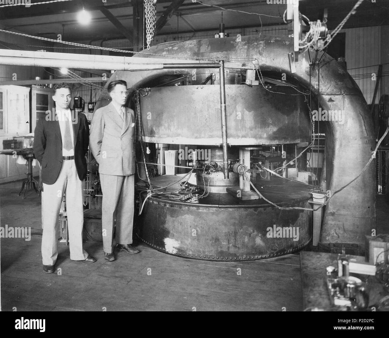 . English: M. Stanley Livingston (L) and Ernest O. Lawrence in front of 27-inch cyclotron at the old Radiation Laboratory at the University of California, Berkeley. 1934. Archive creator: Department of Energy 2 27-inch cyclotron Stock Photo