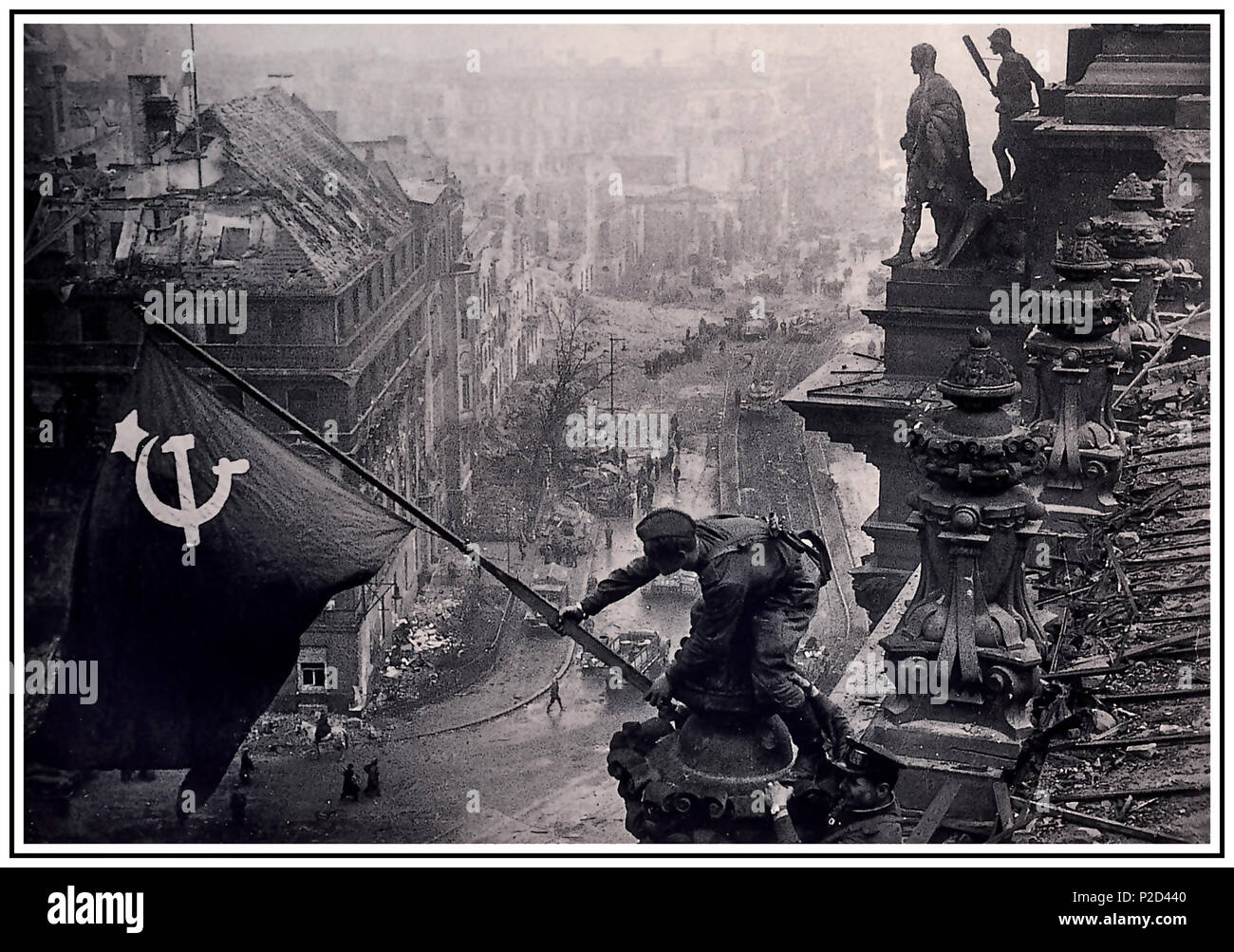 RUSSIAN FLAG BERLIN 1945 REICHSTAG ICONIC World War 2 Germany. Russian soldier raising Soviet Hammer and Sickle flag over the Nazi Reichstag chancellory, a historic World War II photograph, taken during the Battle of Berlin on 2 May 1945. It shows Meliton Kantaria and Mikhail Yegorov raising the Soviet flag over the former Nazi Germany seat of power, the Berlin Reichstag Berlin Germany.. Archive image digitally restored and processed to its original impact and quality potential. Stock Photo