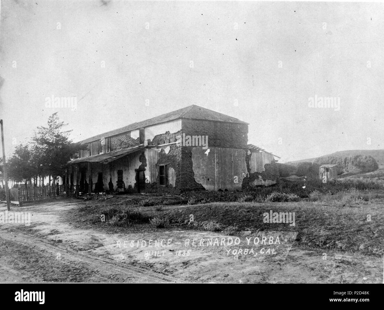 . English: Looking northwest towards the Bernardo Yorba adobe house, also called Hacienda Yorba de San Antonio. The south awning and underlying plaster is still intact which is missing in photos taken December of 1919. The roof is not damaged on the east end which an eyewitness account says was present in 1917 which dates the photo before then. The Hacienda was built in 1835 on the north bank of the Santa Ana River on the Rancho Cañón de Santa Ana. Contributed to the Yorba Linda Public Library by the First American Corporation. circa 1900. Unknown 7 Bernardo Yorba Adobe Stock Photo