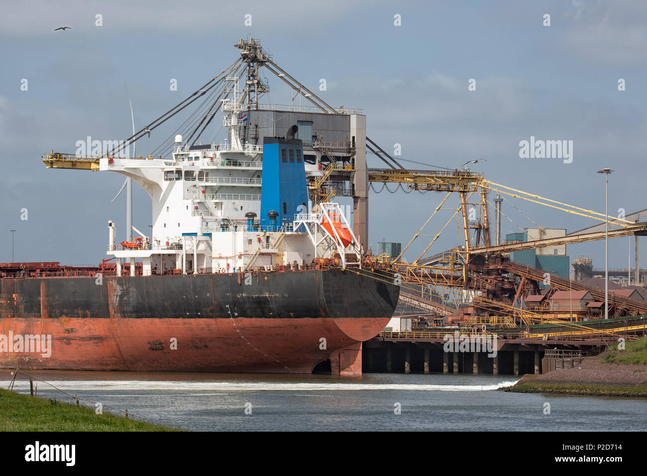 Steel factory Dutch harbor IJmuiden with cargo carrier in front, Stock Photo