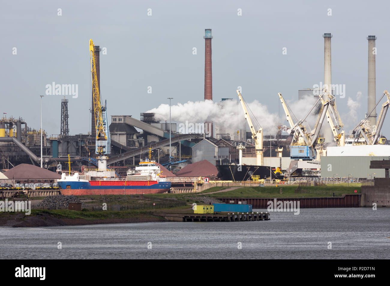 Steel factory Dutch harbor IJmuiden with cargo carrier in front, Stock Photo