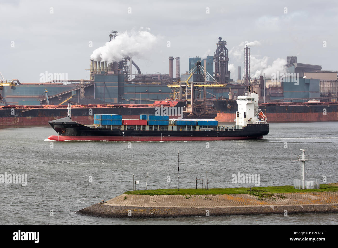 Steel factory Dutch harbor IJmuiden with cargo carrier in front, Stock Photo