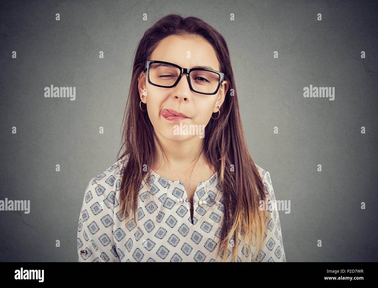 girl in glasses sticking out her tongue Stock Photo