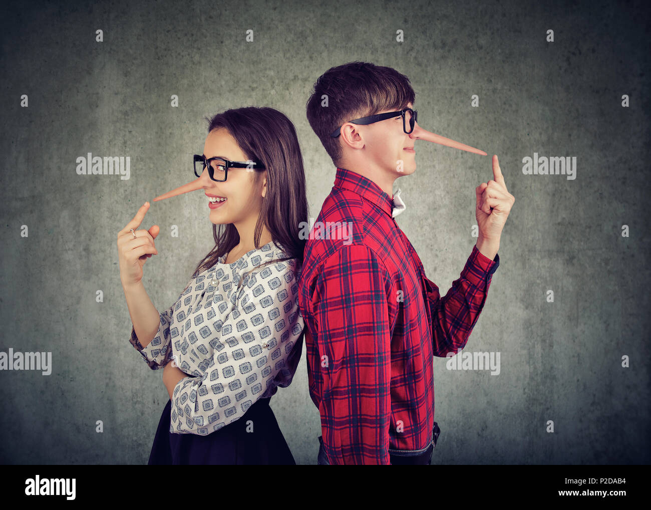 Young couple of cheaters, satnding back to back two liars Stock Photo