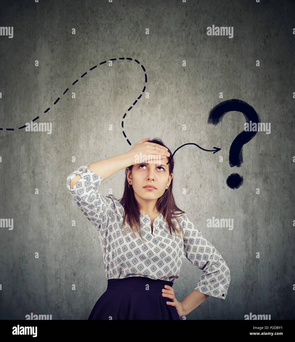 Young woman thinking hard trying to remember has a question Stock Photo