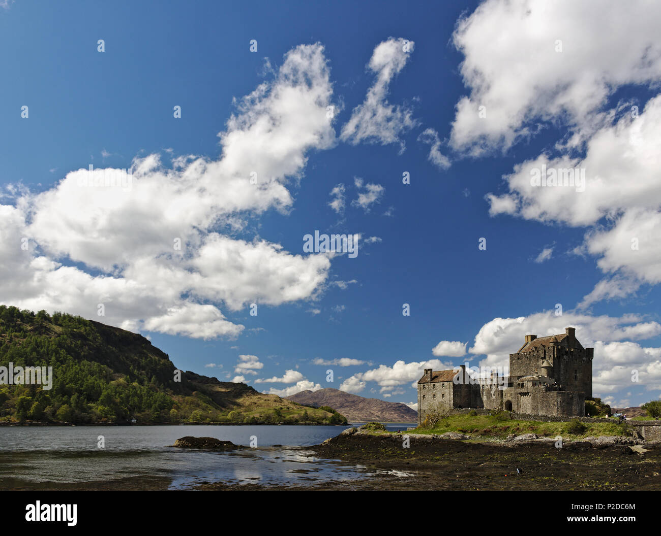 Dornie, Scotland - May 12th, 2018 - Eilean Donan Castle with a clear blue sky and fluffy white clouds Stock Photo