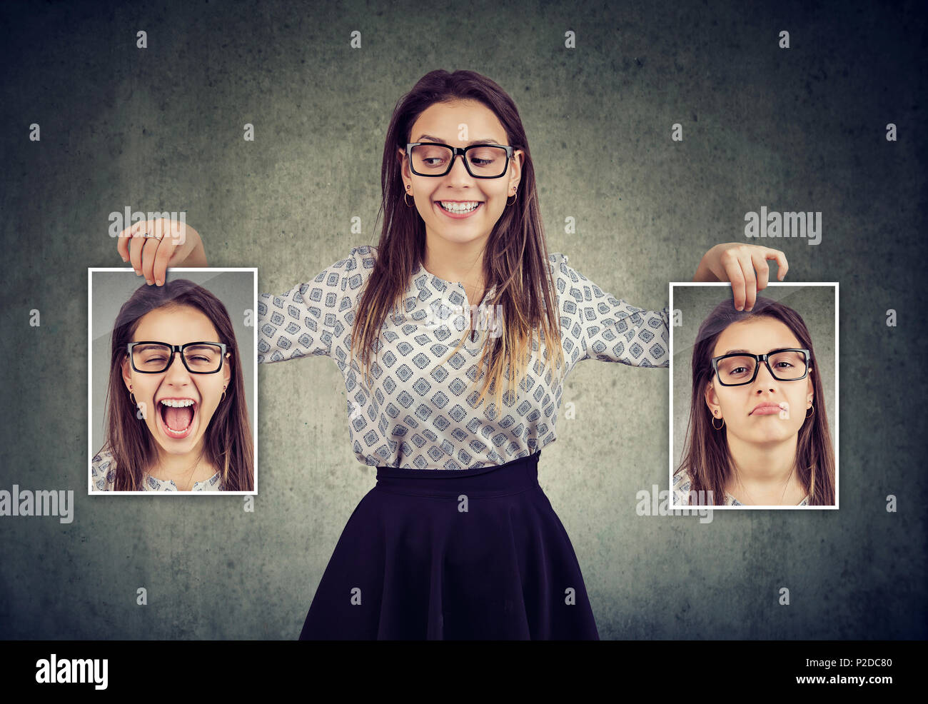 Happy woman holding two different face emotion masks of herself Stock Photo
