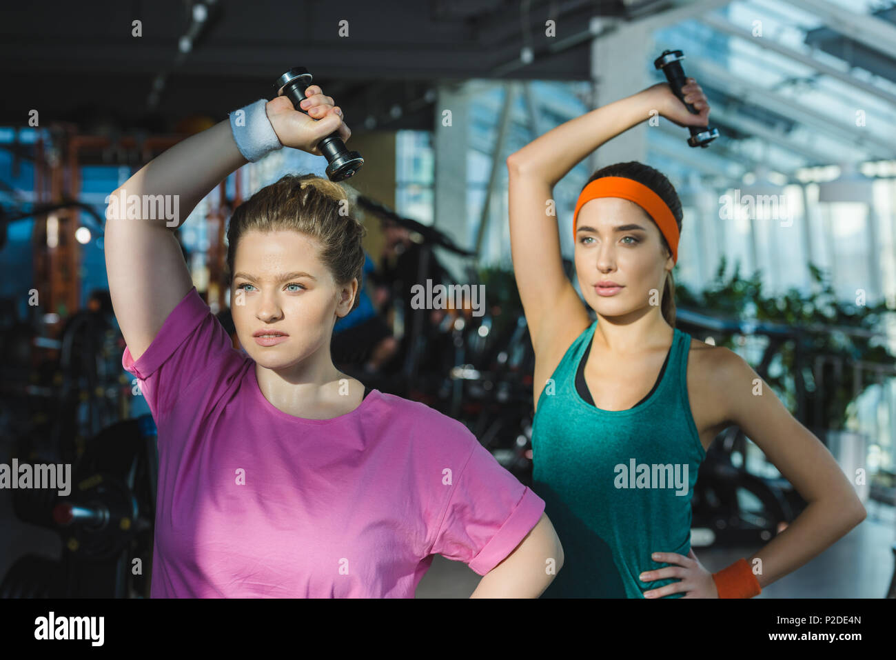 Sporty and overweight women training with dumbbells at gym Stock Photo