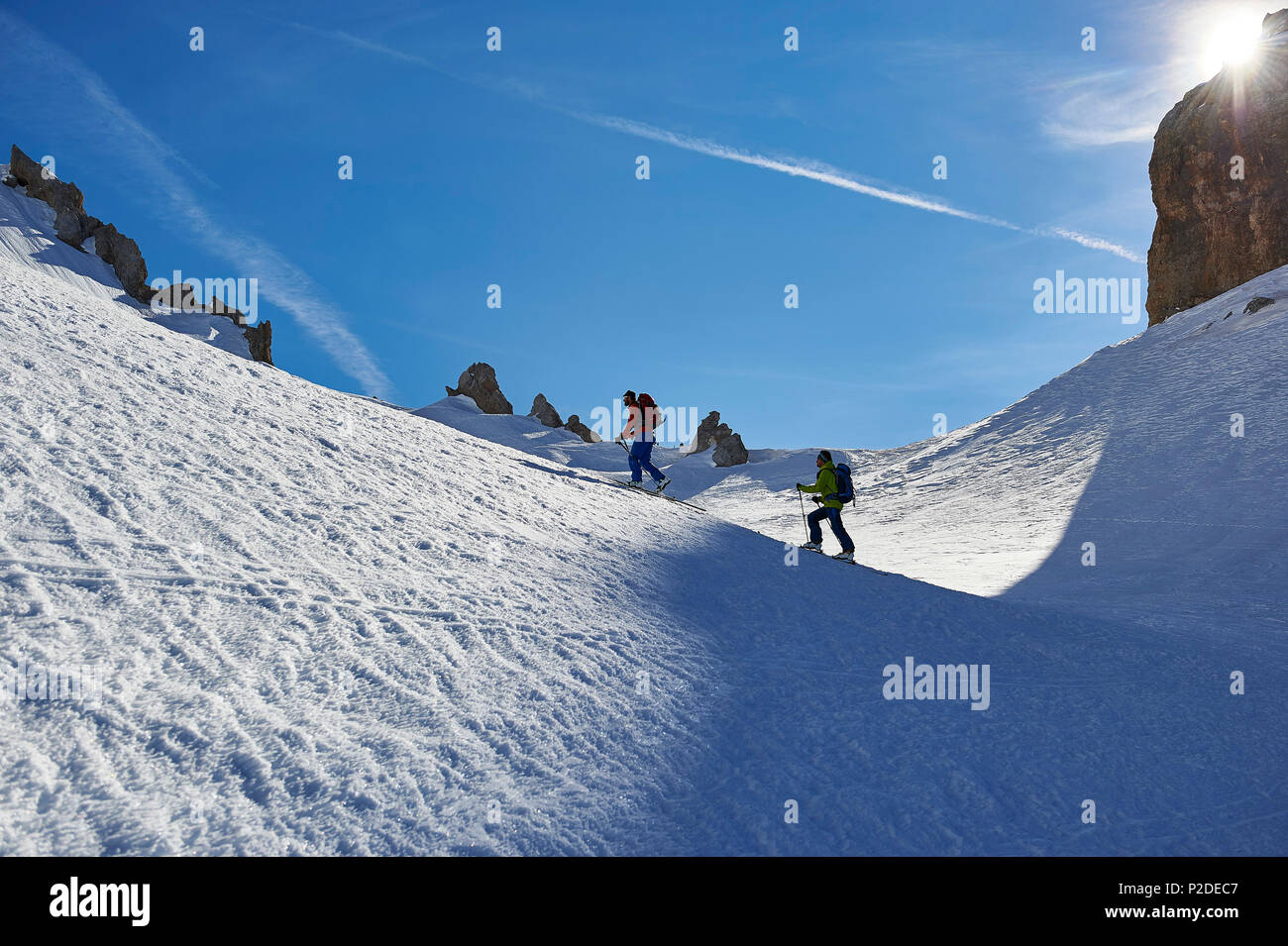 two-men-are-skitouring-right-beneath-the-peak-of-bocchetta-die-tres