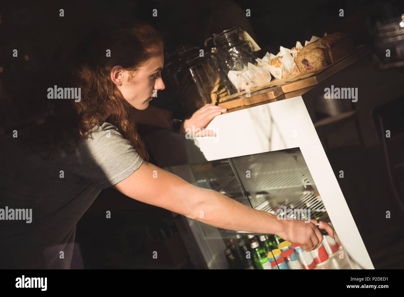 Waiter arranging bottle in refrigerator Stock Photo
