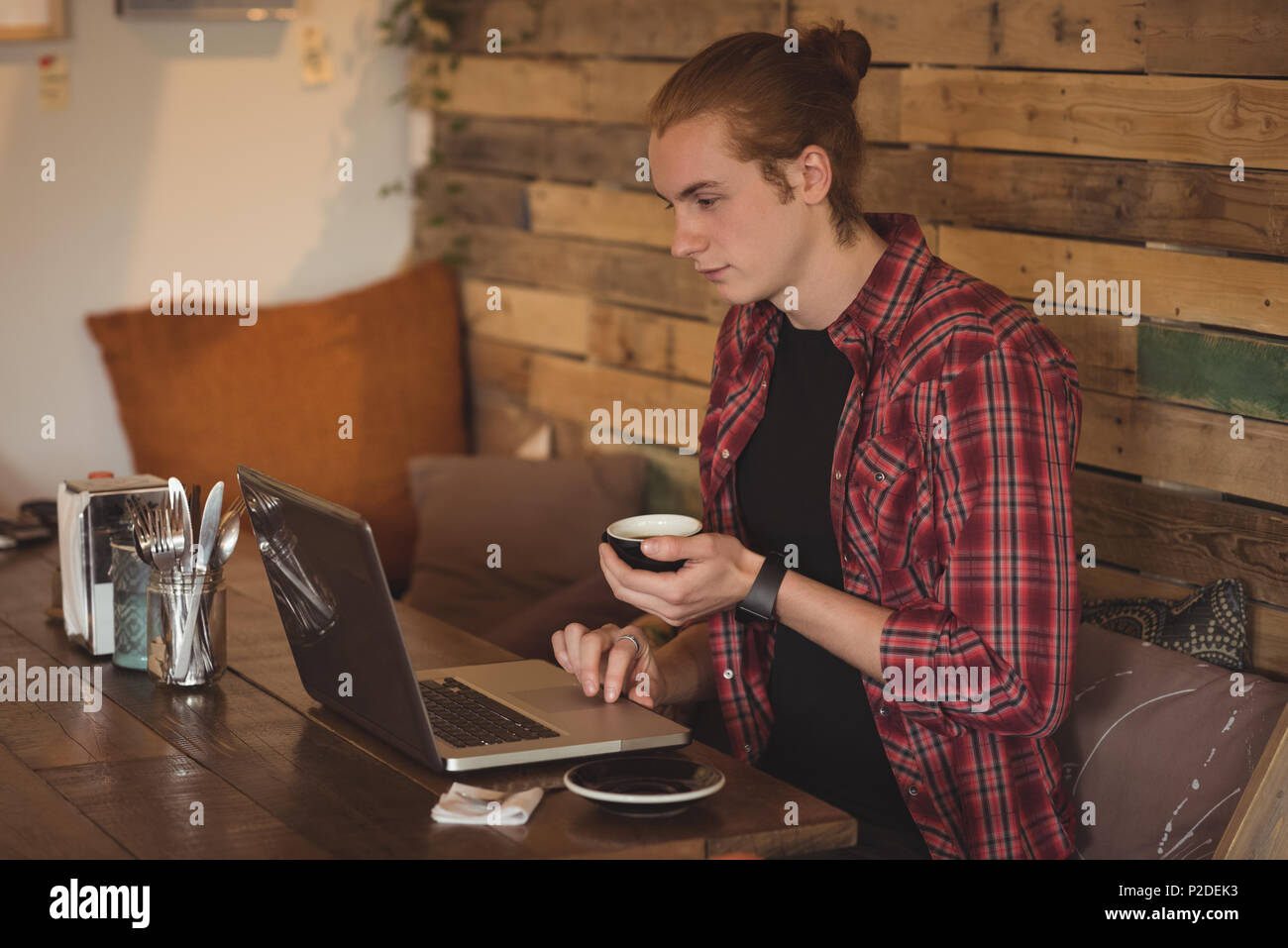 Man using laptop while having coffee Stock Photo