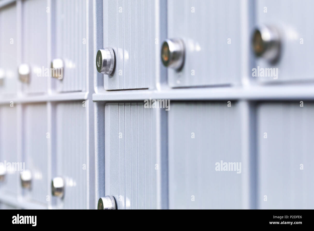 Metal mailboxes and lock in business center of an urban neighborhood. Mail boxes in rows at entrance of modern building. Security storage mailroom Stock Photo
