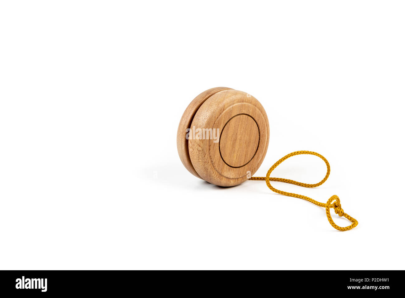 Close up of a wooden yo-yo with yellow string on white background. Stock Photo