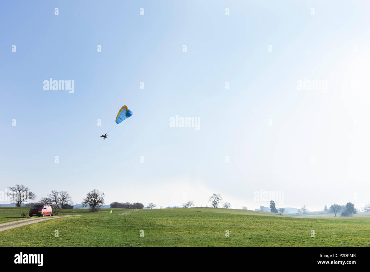 Motor-Paraglider starting off from a meadow, Penzberg, Bavaria, Germany Stock Photo