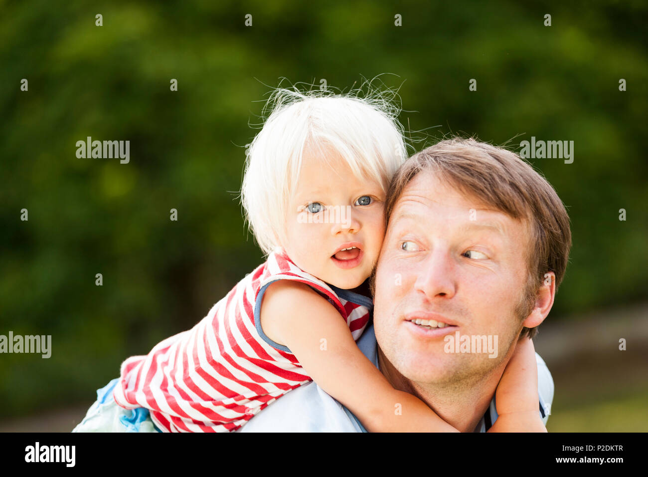 two-year-old girl on her father's back, Speyer, Rheinland-Pfalz, Germany Stock Photo