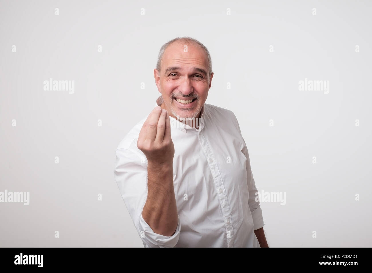 Bald handsome mature man looking angry showing italian gesture over white background. Stock Photo