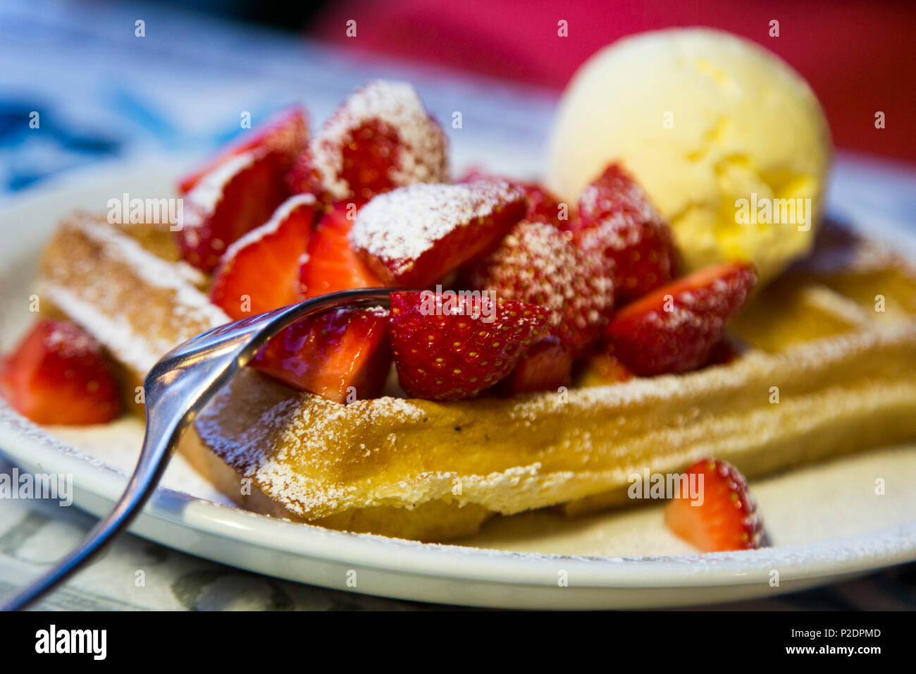 Delicious Belgian waffle with fresh strawberries and vanilla ice cream at a restaurant in the Old Town, Bruges Brugge, Flemish R Stock Photo