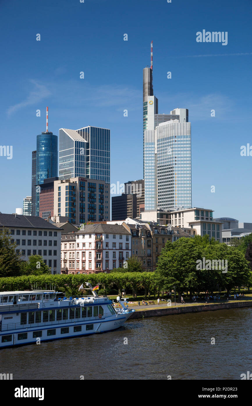 River cruise ship River Rhapsody GCCL Cruises moored along the Main river with financial district skyscrapers behind, Frankfurt Stock Photo