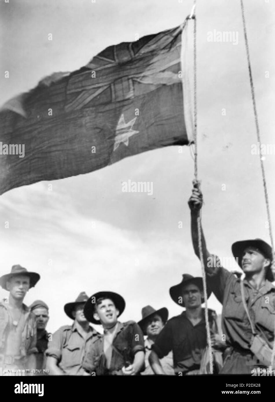 . Australian War Memorial (AWM) catalog number 090925. Members of the Australian 2/4th Cavalry Commando Squadron raise the Australian flag over Sadau Island on 30 April 1945. This was the first time Australian troops had captured non-Australian territory during the Pacific War. 30 April 1945. Not recorded 5 Aust flag Sadau (090925) Stock Photo