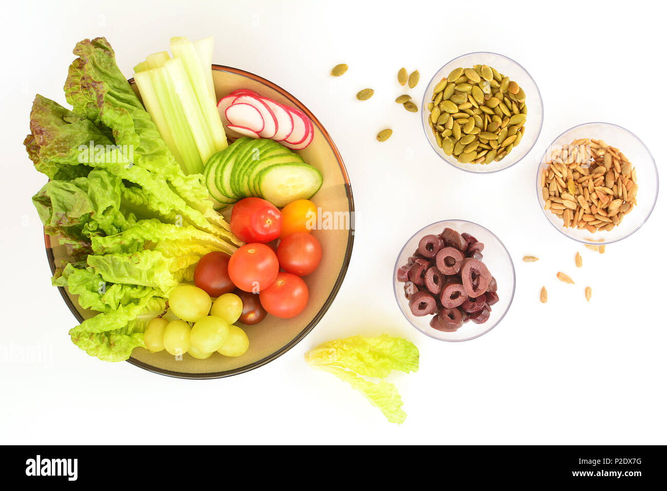 Healthy organic salad ingredients with seeds and olives in flat lay