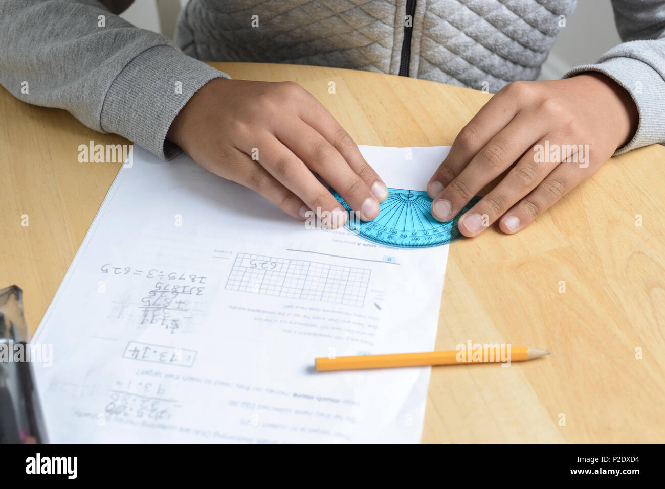 Child  working on maths homework-using protractor Stock Photo