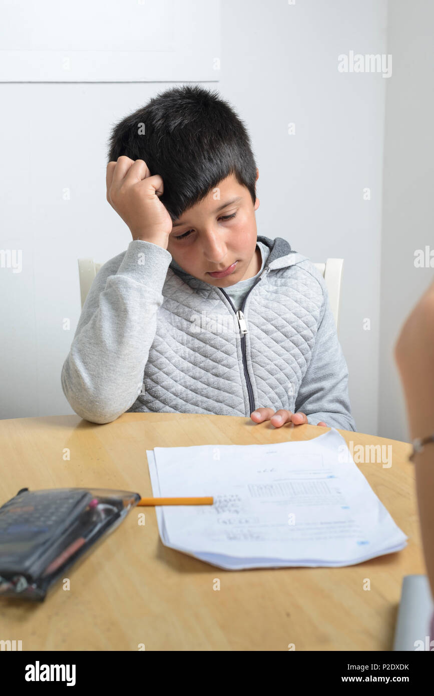 Private tuition -10 years child  getting help with math-looking puzzeld and overwhelemed Stock Photo