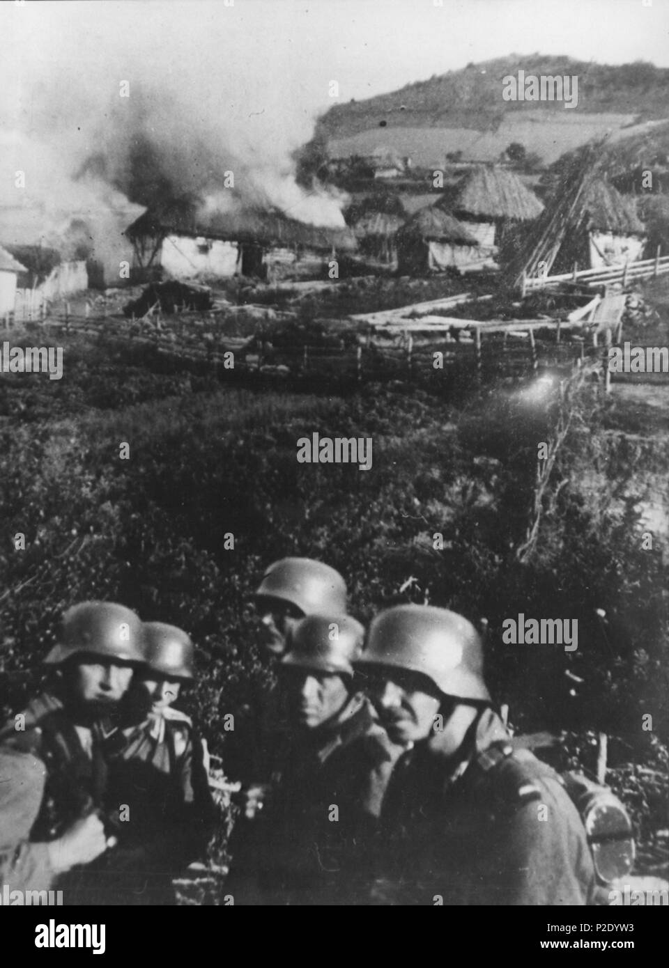 . English: Germans set fire to a Serbian village near Kosovska Mitrovica. circa 1941 22 Germans in Kosovska Mitrovica Stock Photo