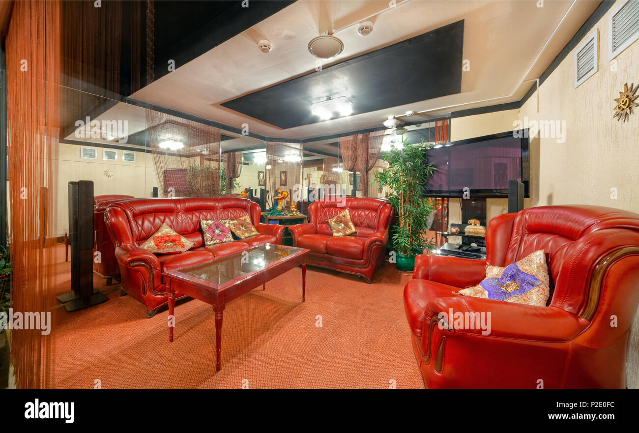 MOSCOW - SEPTEMBER 2014: Interior and furnishings of the restaurant of Indian cuisine 'KHAJURAHO'. Separate VIP lounge with red leather sofas Stock Photo