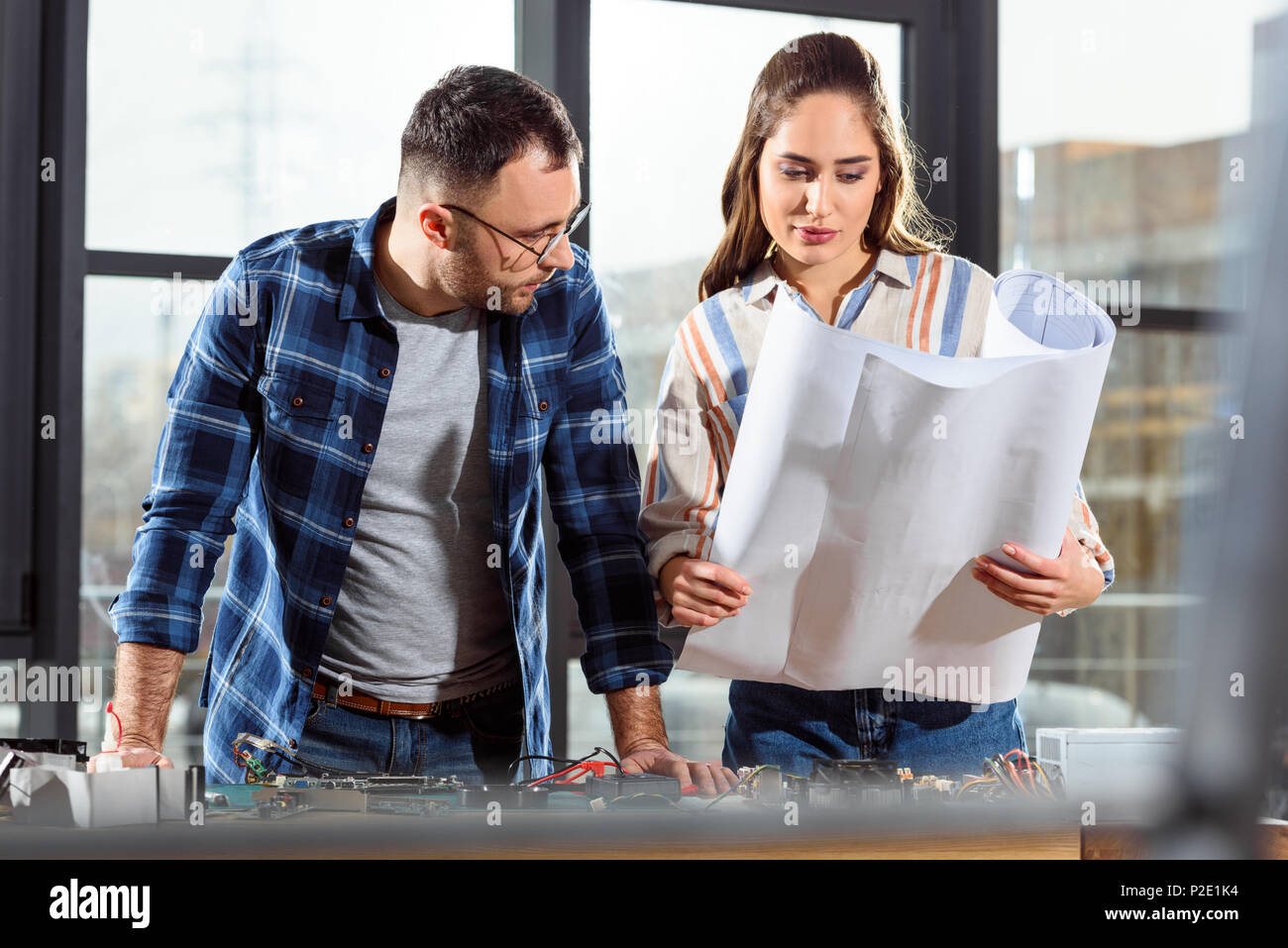 Woman showing project blueprint to male engineer Stock Photo