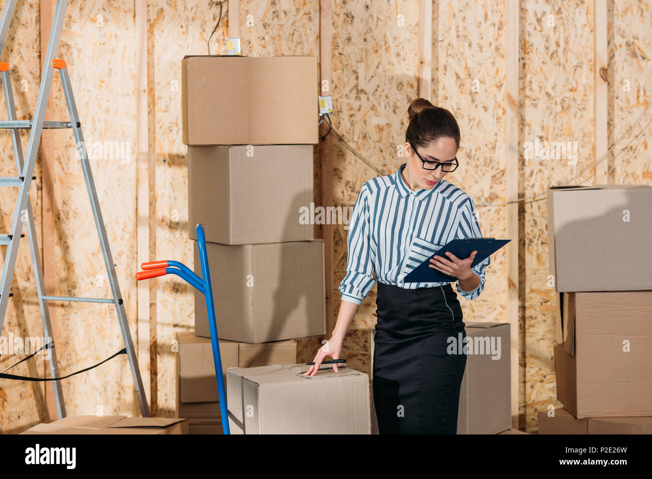 Businesswoman with clipboard checking delivery packages Stock Photo