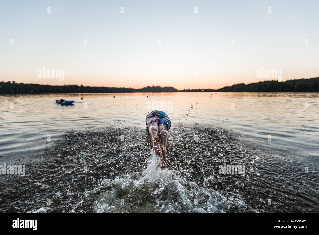 Young man jumping into the water of a lake, Freilassing, Bavaria, Germany Stock Photo