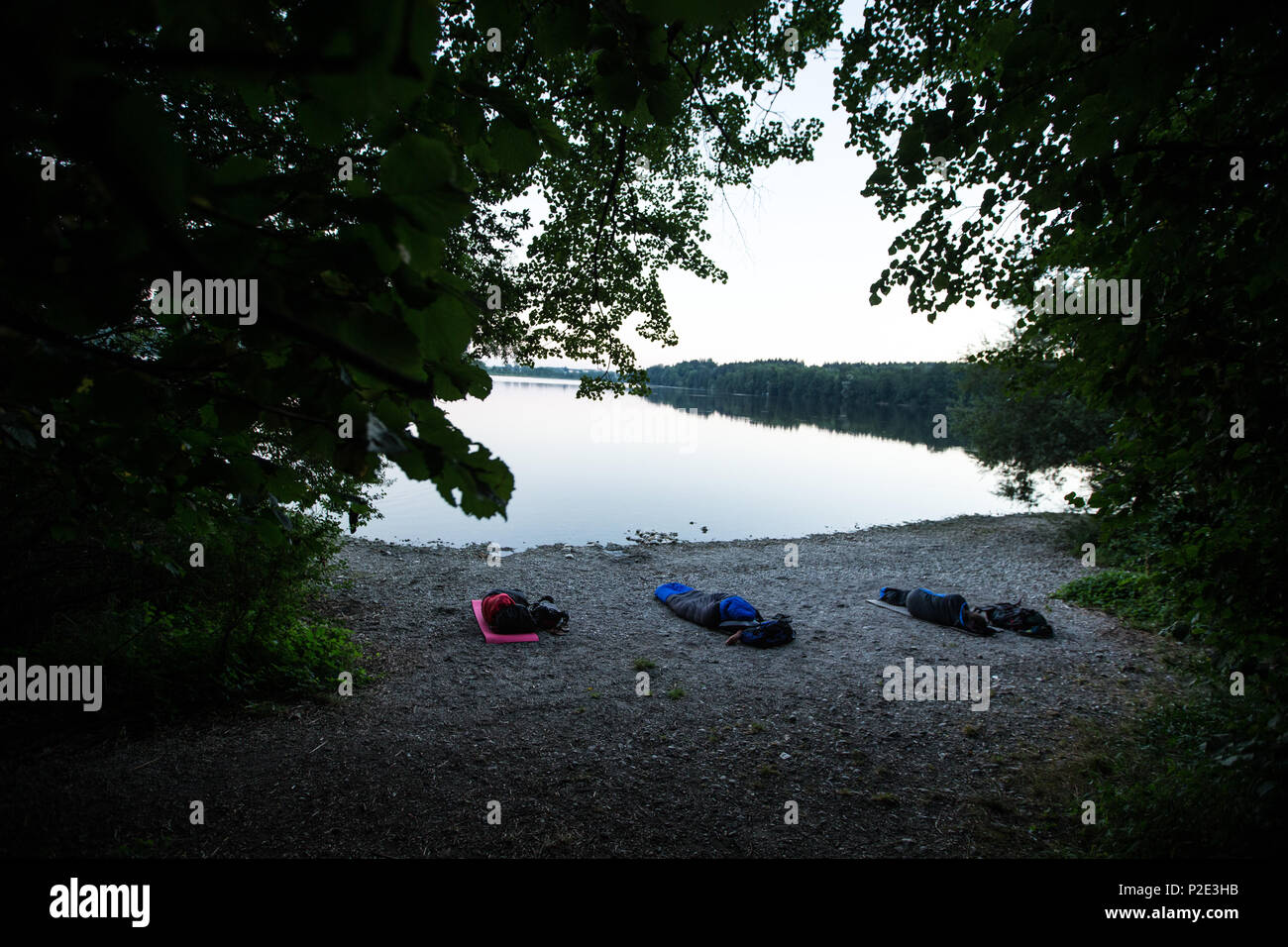 Three Young Man Sleeping Outside Only With Sleeping Bags At A Lake