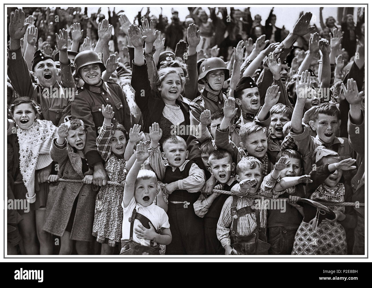 1930’s Adolf Hitler attracting an ecstatic crowd of all ages giving him the Nazi Seig Heil salute Germany Stock Photo