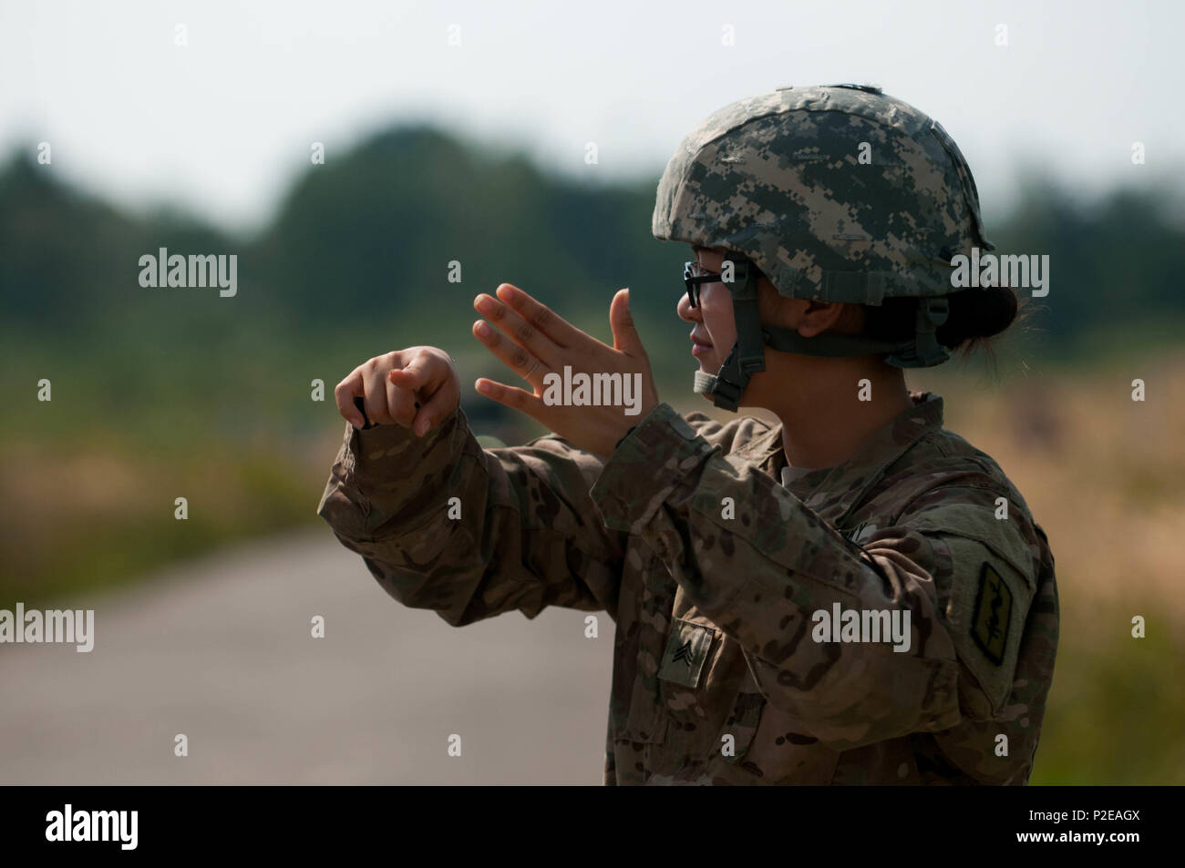 Sgt. Esther Yu, medic with 557th Medical Company (Area Support), gives hand signals to guide the Ukrainian Soldier driving the field litter ambulance during a road test at Yavoriv Training Area, Ukraine on Sep. 9, 2016. A team of medics and a mechanic from 557th Medical Company (Area Support) and 212th CSH are working together to conduct field littler ambulance and medical equipment set familiarization with the Ukrainian military from Sep 5 to 16, 2016. (U.S. Army photo by Capt. Jeku Arce, 30th Medical Brigade Public Affairs) Stock Photo