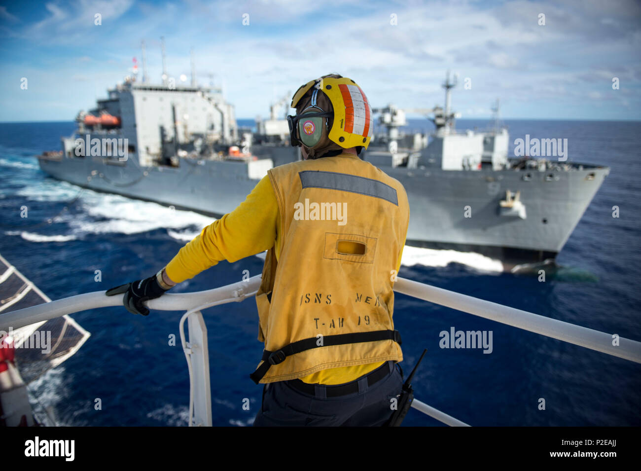160910-N-QW941-065 PACIFIC OCEAN (Sept. 10, 2016) Aviation Boatswain's Mate (Handling) 3rd Class Tyler Randrup, from Fresno, California, watches dry cargo ship USNS Matthew Perry (T-AKE 9), refuel hospital ship USNS Mercy (T-AH 19). Deployed in support of Pacific Partnership 2016, Mercy is sailing to her homeport of San Diego. (U.S. Navy photo by Mass Communication Specialist 3rd Class Trevor Kohlrus/Released) Stock Photo