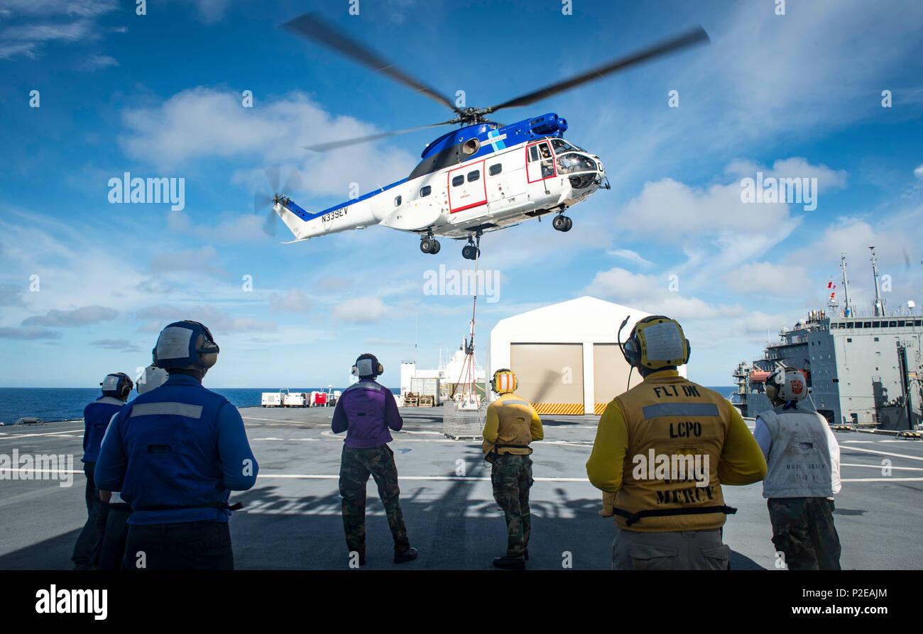 160910-N-QW941-096 PACIFIC OCEAN (Sept. 10, 2016) Flight deck personnel assigned to hospital ship USNS Mercy (T-AH 19), watch as an SA-330J Puma helicopter assigned to dry cargo ship USNS Matthew Perry (T-AKE 9), delivers supplies to Mercy during a vertical replenishment. Deployed in support of Pacific Partnership 2016, Mercy is sailing to her homeport of San Diego. (U.S. Navy photo by Mass Communication Specialist 3rd Class Trevor Kohlrus/Released) Stock Photo