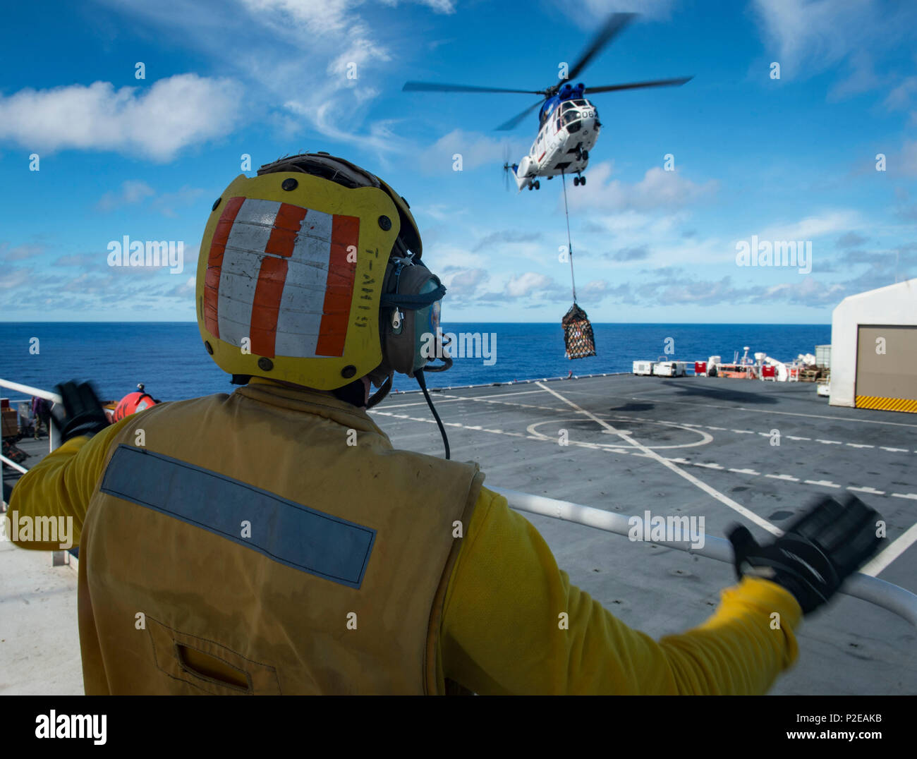 160910-N-QW941-271 PACIFIC OCEAN (Sept. 10, 2016) Aviation Boatswain's Mate (Handling) 3rd Class Tyler Randrup, from Fresno, California, guides an SA-330J Puma helicopter assigned to dry cargo ship USNS Matthew Perry (T-AKE 9), during a vertical replenishment with hospital ship USNS Mercy (T-AH 19). Deployed in support of Pacific Partnership 2016, Mercy is sailing to her homeport of San Diego. (U.S. Navy photo by Mass Communication Specialist 3rd Class Trevor Kohlrus/Released) Stock Photo