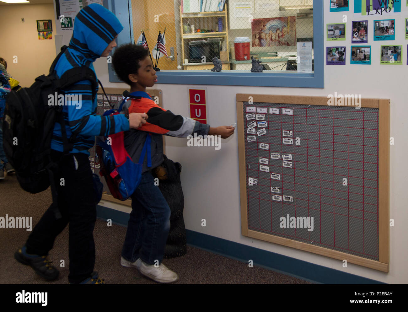 Joshua Gaspard (left to right), 9, and Devin Hogan, 7, sign their name on  the board on their way to school from Ketchikan School Age Centers at Joint  Base Elmendorf-Richardson, Alaska, Sept.