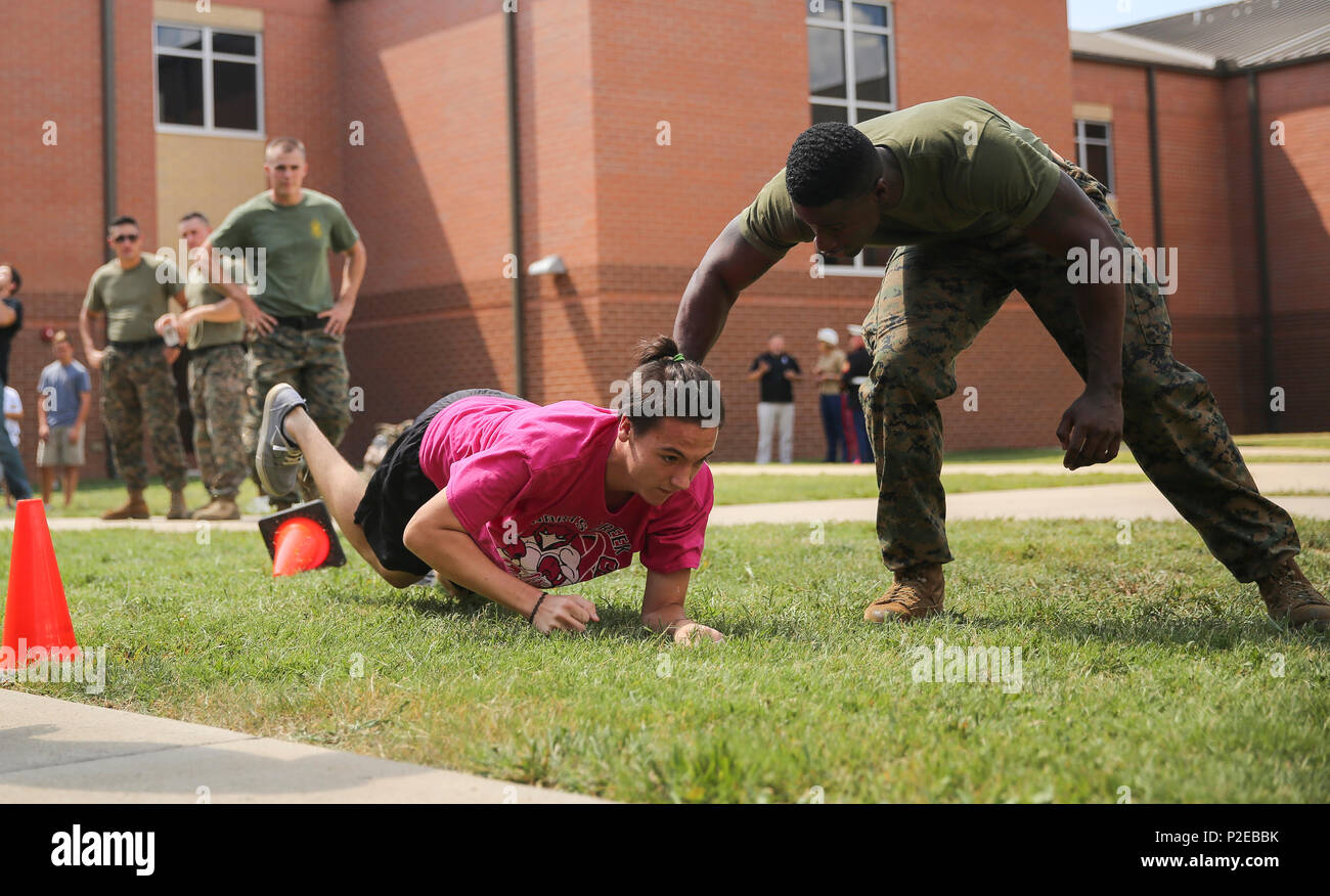 A high school student crawls through the grass during a mock combat fitness test set up by the U.S. Marine Corps with Marine Wing Support Squadron 274, 2nd Marine Air Wing, based out of Marine Corps Air Station Cherry Point, at Stewart Creek High School in Smyrna, Tenn., Sept. 6, 2016. More than 800 Marines from all over the country travelled to Nashville in support of Marine Week to commemorate the unwavering support of the American people, and show the Marine Corps’ continued dedication to protecting the citizens of this country. (U.S. Marine Corps photo by Cpl. Kaitlyn V. Klein) Stock Photo