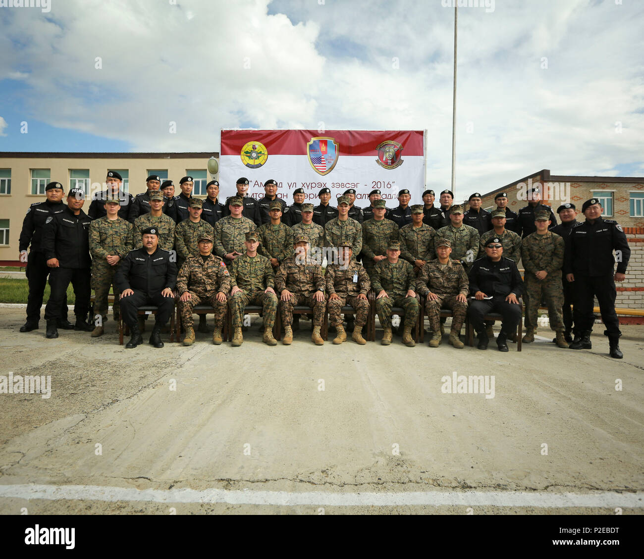 Mongolian police officers pose for a group photo with U.S. Marines and Mongolian Armed Forces leadership during the opening ceremony for Non-Lethal Weapons Executive Seminar (NOLES) 2016 at the Five Hills Training Area, Mongolia, Sept. 12, 2016. NOLES is a regularly scheduled field training exercise and leadership seminar hosted annually by various nations throughout Asia-Pacific. (U.S. Marine Corps photo by Cpl. Jonathan E. LopezCruet) Stock Photo