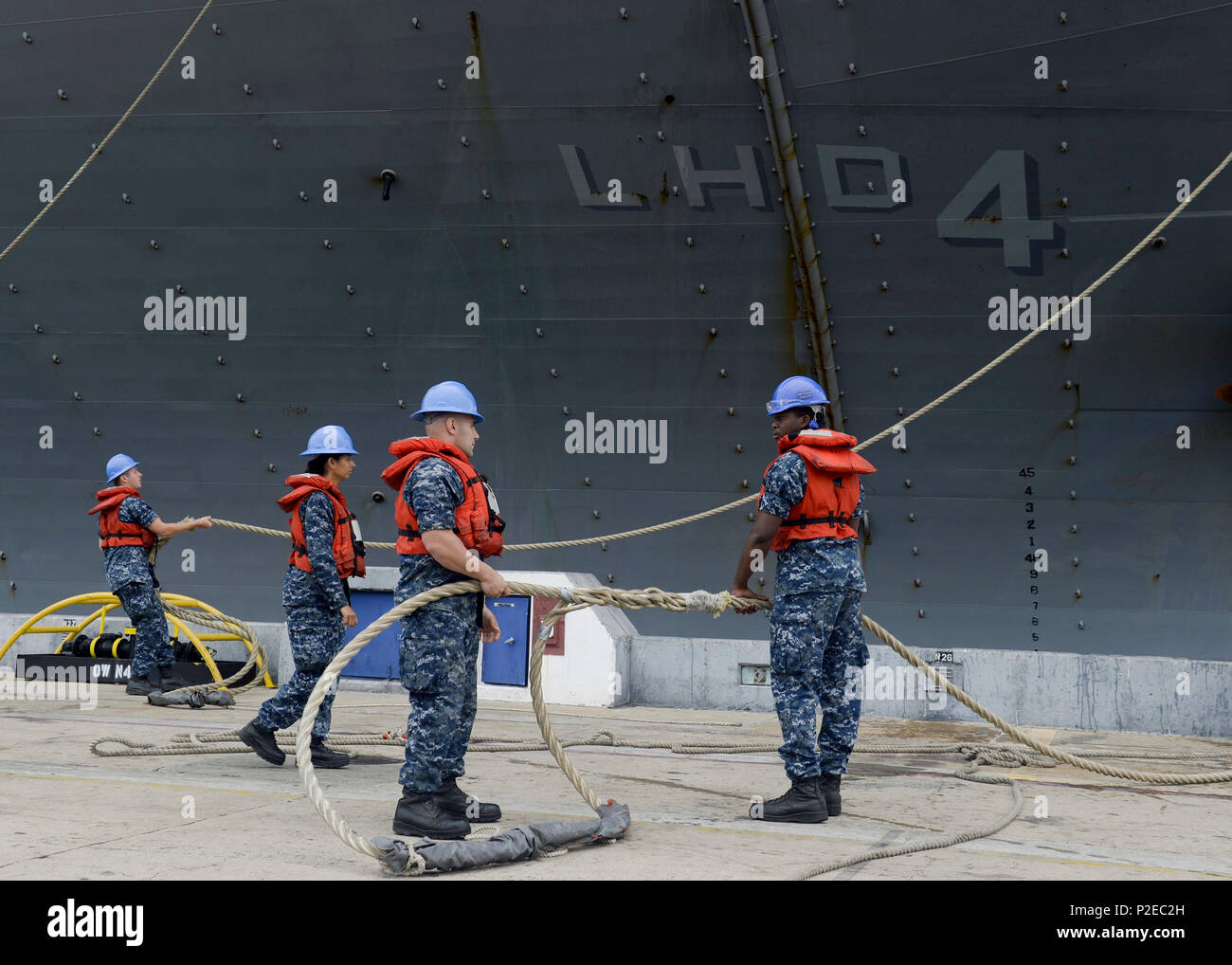 Sailors from USS Essex (LHD 2) manage mooring lines as USS Boxer (LHD 4 ...