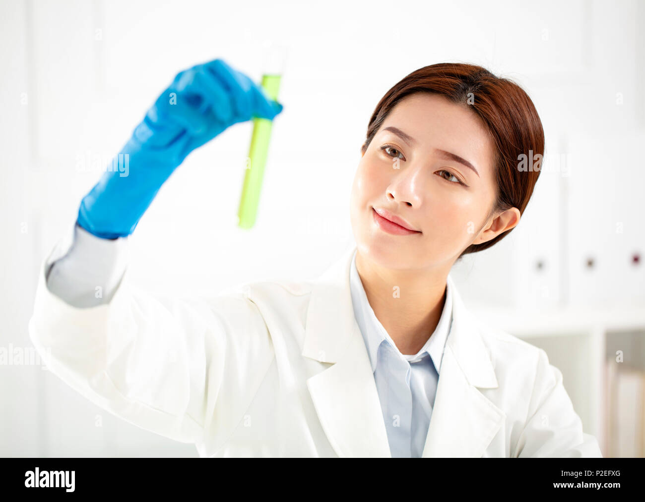 asian female scientist looking at test tube Stock Photo