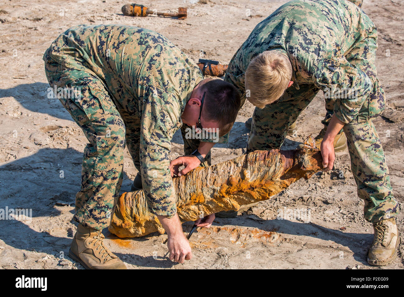 Marines tape a shaped charge on to unexploded ordnance aboard Marine Corps Air Station    Beaufort Sept. 8. The unexploded ordnance was disposed of during this multi-purpose training    event. The Marines are Explosive Ordnance Disposal, Marine Wing Support Detachment 31. Stock Photo