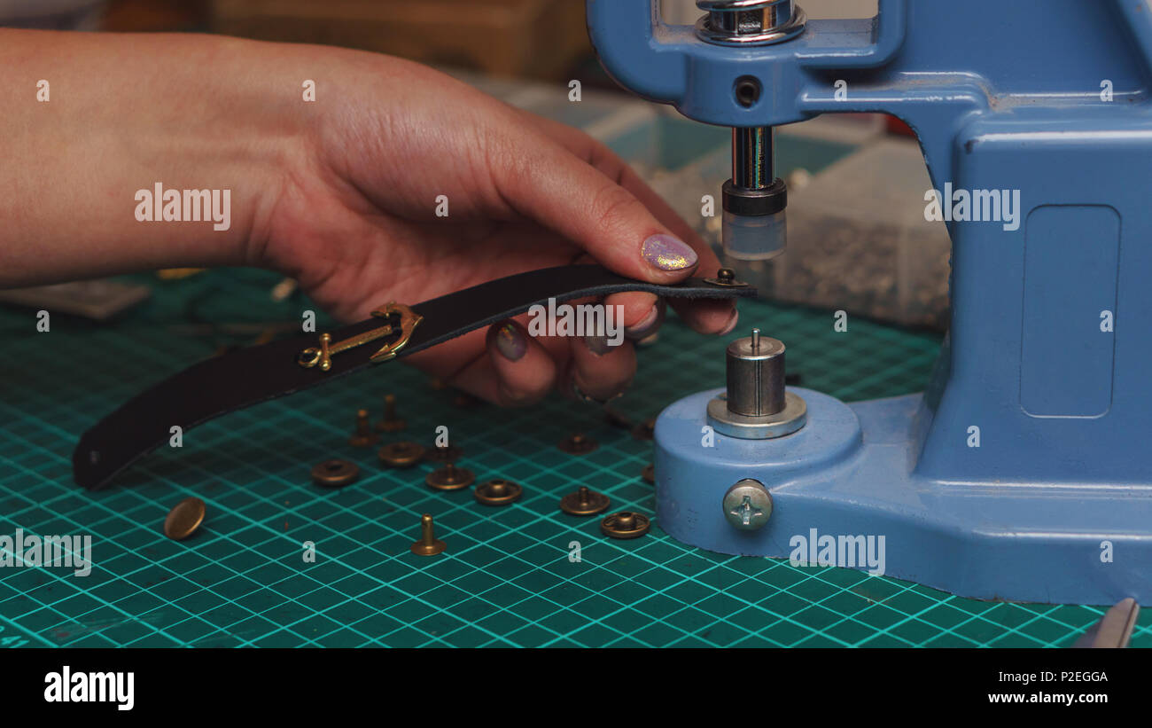 Tanner puts rivets on leather bracelet. Close-up photo. Process of ...
