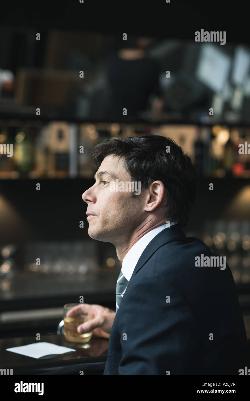 Thoughtful businessman having glass of whisky Stock Photo