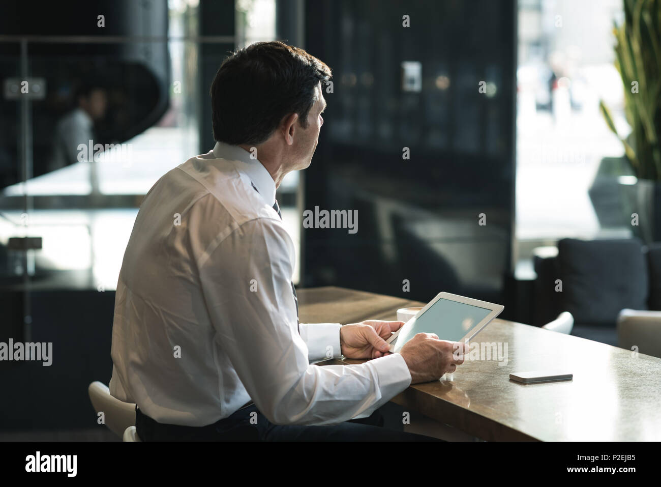 Thoughtful businessman using digital tablet Stock Photo