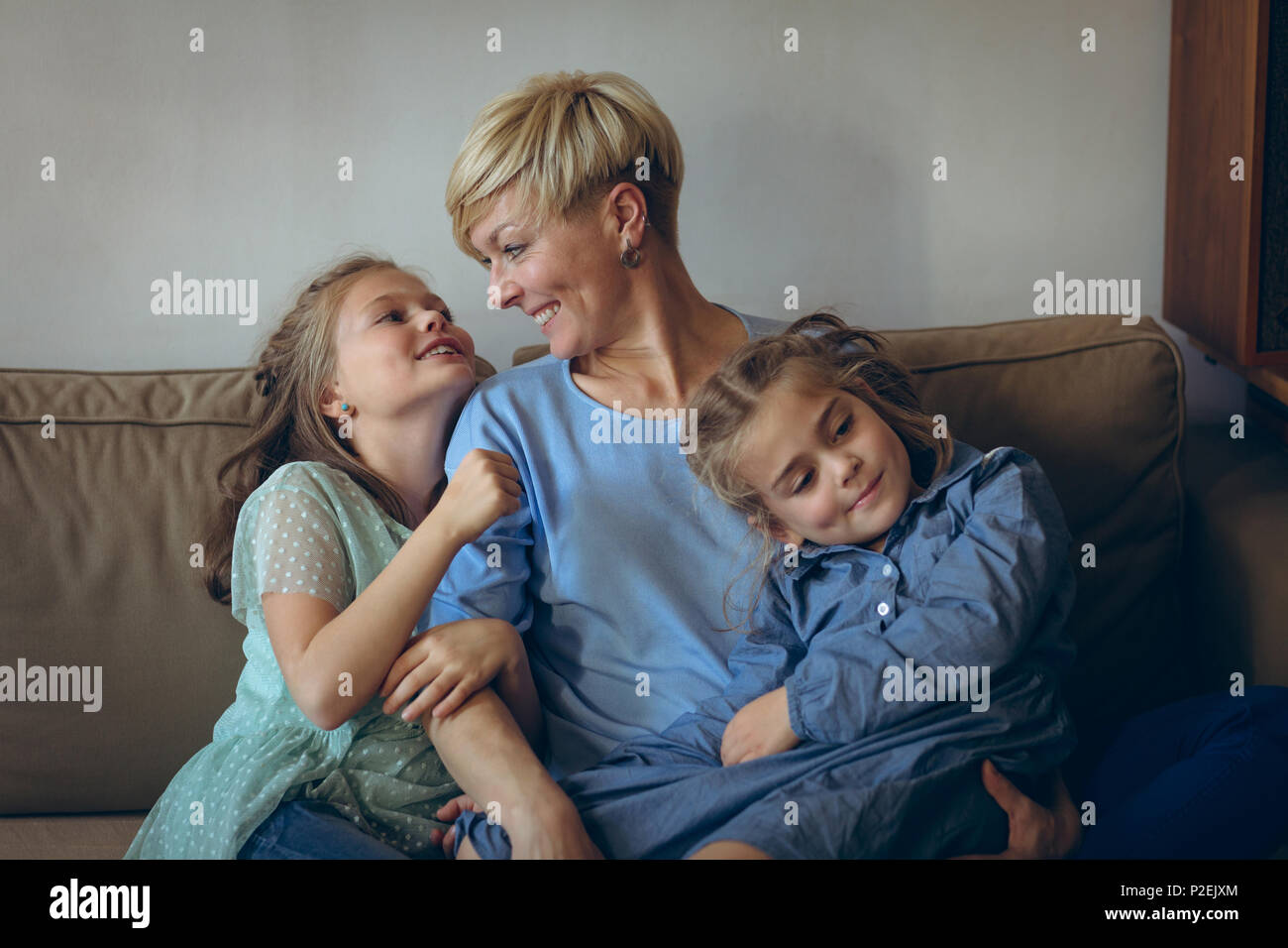 Mother and daughters relaxing on sofa Stock Photo