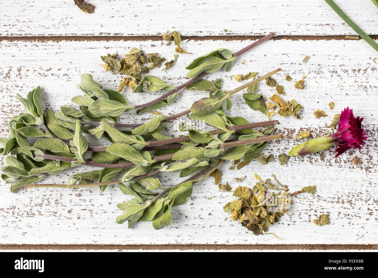 Fresh and dry Marjoraml herbs on a rustic table top with edible flowers