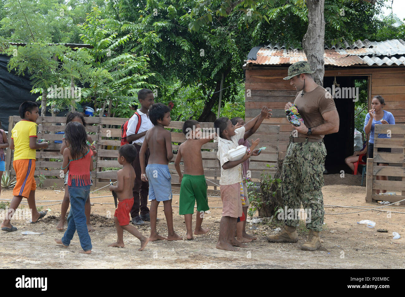 CARTAGENA, Colombia (Sept. 12, 2016) - Lt. Ryan Cahill, assigned to Fleet Logistics Center San Diego, passes out snacks to local children. Lt. Cahill is currently deployed as part of Southern Partnership Station 2016’s (SPS 16) Construction Engagement Team in Cartagena constructing a new latrine building for the Cabildo Indigena Zenu community. Once completed the community will no longer rely on outhouse style facilities. SPS16 is an annual deployment of U.S. ships to the U.S. Southern Command's area of responsibility in the Caribbean and Latin America. The exercise involves information sharin Stock Photo