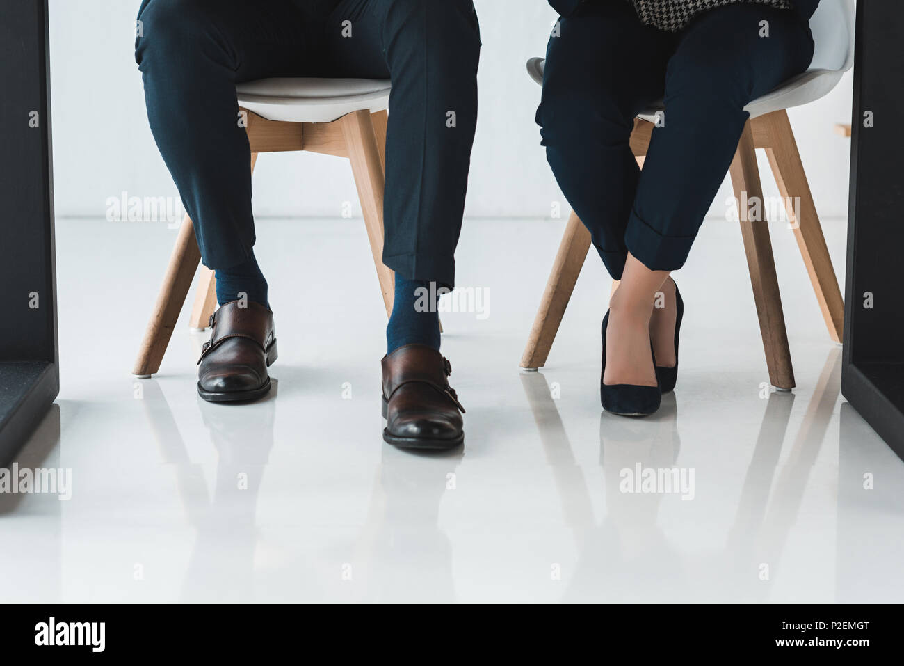 Partial view of businessman and businesswoman working by table in light ...